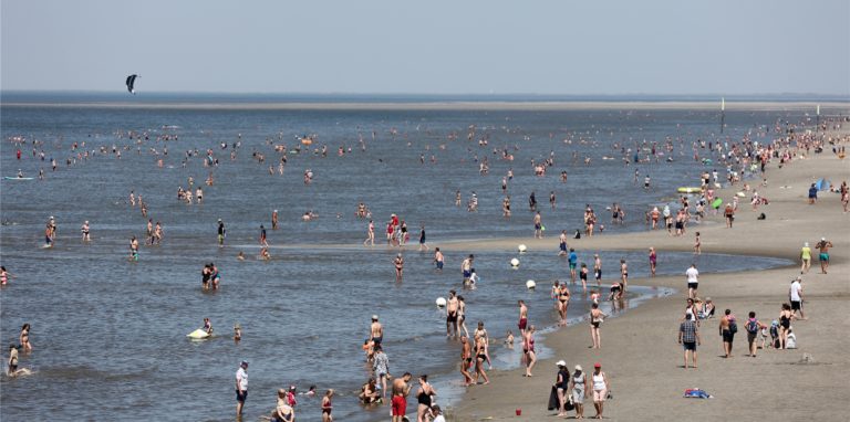 Zahlreiche Urlauber genießen die Sonne am Strand.
