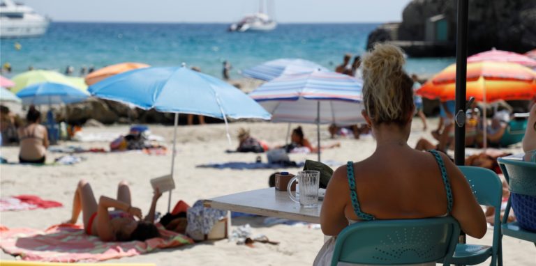 Menschen halten sich am Strand von Cala Major, in der Nähe von Palma auf Mallorca, auf.