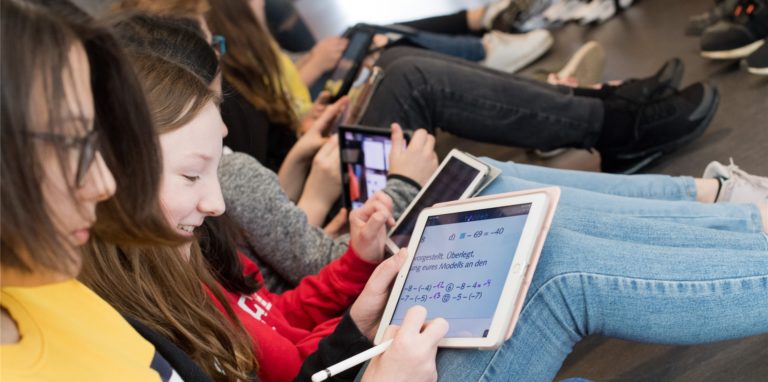 Schüler einer 7. Klasse lernen mit iPads im Matheunterricht.