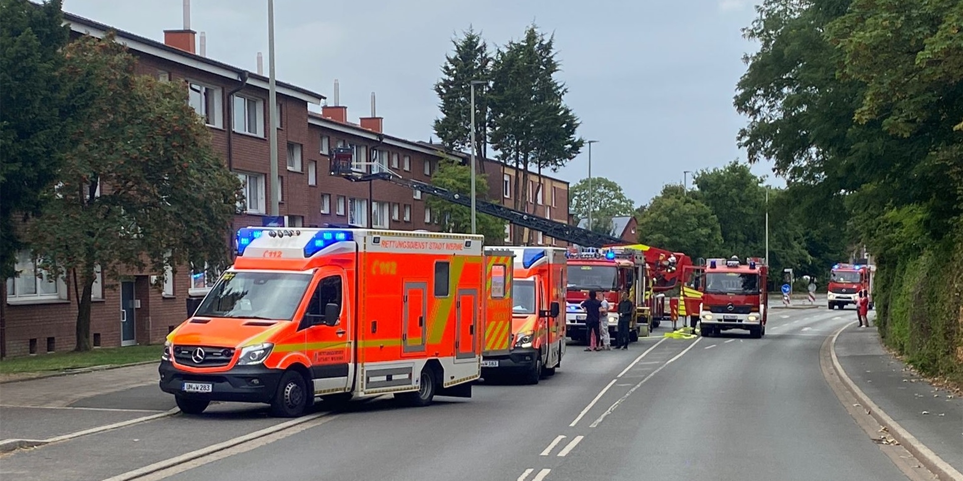 Feuerwehrautos und Krankenwagen stehen auf einer Straße.