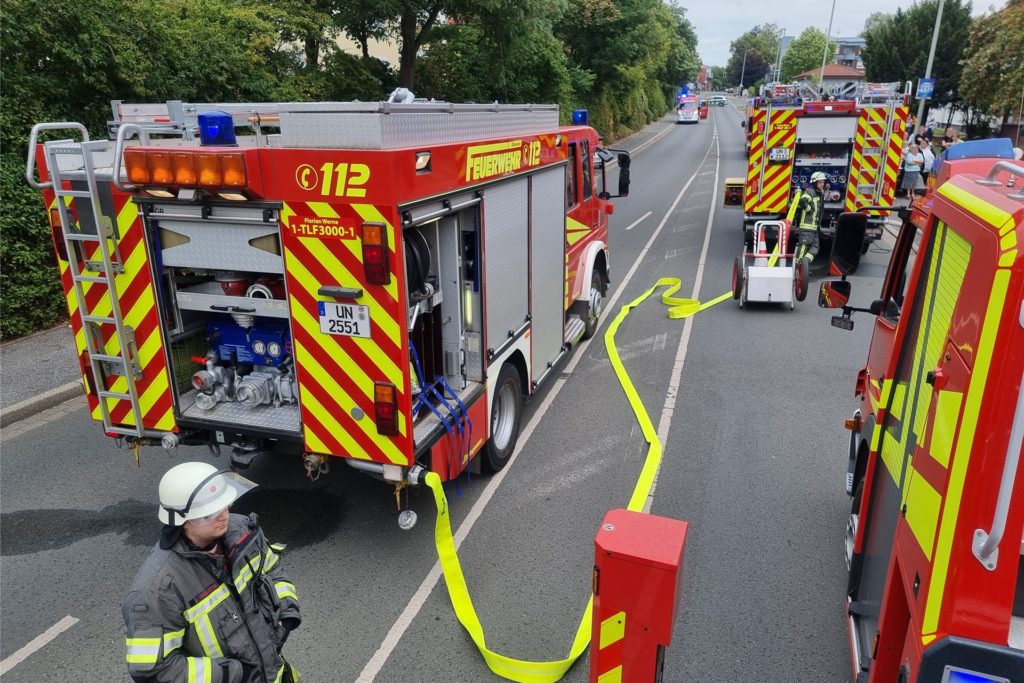 Feuerwehrautos stehen auf einer Straße. Feuerwehrautos stehen auf einer Straße.