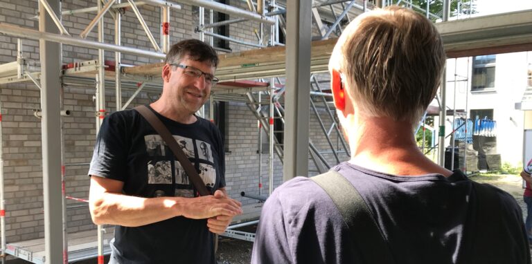 Andreas Drohmann im Gespräch mit einem Handwerker auf der Baustelle.