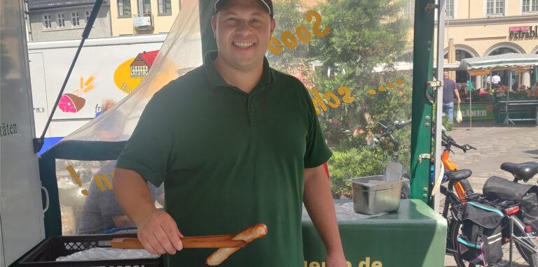 Moritz Abel grillt auf dem Wochenmarkt in Unna Bratwürstchen. Jetzt musste auch er seine Preise erhöhen.