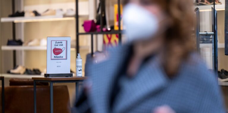 Ein Schild am Eingang eines Schuh-Geschäfts in der City-West weist auf die Pflicht zum Tragen einer FFP2-Maske hin.