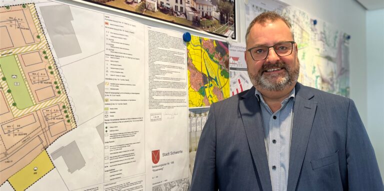 Geschäftsführer Ralf Grobe von der Gemeinnützigen Wohnungsbaugenossenschaft Schwerte schätzt den Energiepreis-Rechner ein. Im Hintergrund Baupläne der Genossenschaft.