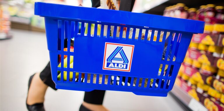 Frau trägt Aldi-Nord-Einkaufskorb.