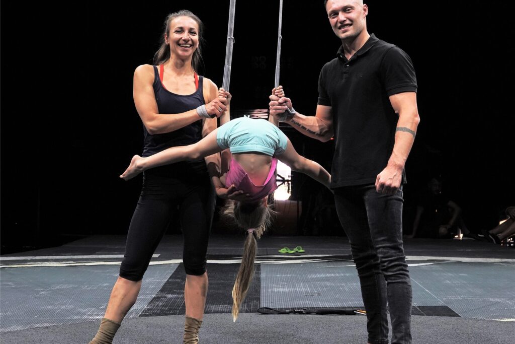 Yuliya Shanchunko (l) und Valentyn Shevchenko stehen neben zwei Stoffbänder zum Turnen, den Strapaten, an denen ihre Tochter Polina übt. Yuliya Shanchunko (l) und Valentyn Shevchenko stehen neben zwei Stoffbänder zum Turnen, den Strapaten, an denen ihre Tochter Polina übt.