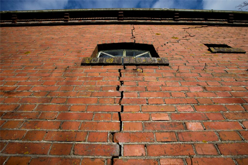 Ein Spalt ist in der Mauer eines Gebäudes zu sehen. Ein Spalt ist in der Mauer eines Gebäudes zu sehen.