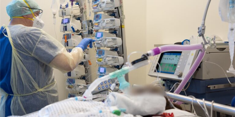 Ein Krankenpfleger versorgt einen schwer an Corona erkrankten Patienten auf der Intensivstation von einem Krankenhaus.
