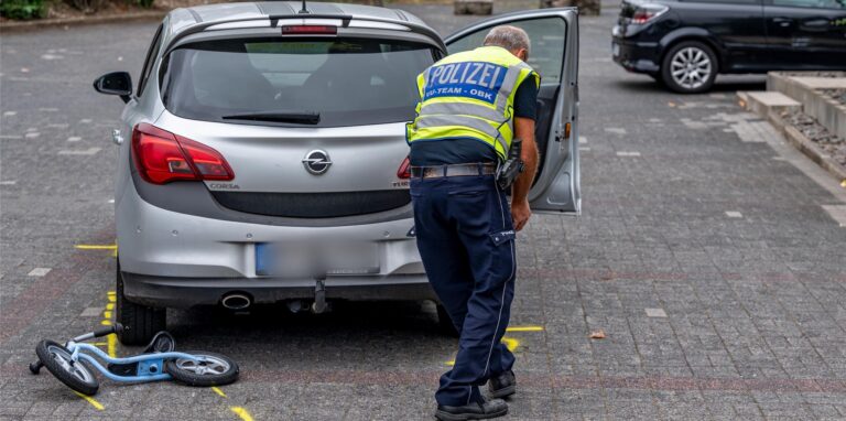 Die Polizei markiert die Unfallstelle auf einem Parkplatz, wo ein Zweijähriger von einem Auto angefahren und schwer verletzt worden war.