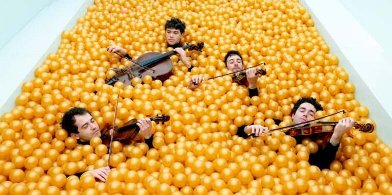 Musiker des Vision String Quartett liegen in einem Bällebad – ein ungewöhnliches Konzert zum Auftakt des Celloherbstes.