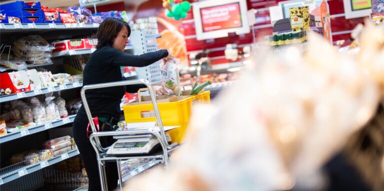 Claudia Karl, Rewe-Mitarbeiterin, packt im Rewe Einkaufsmarkt Schmitz Lebensmittel in eine Postbox.