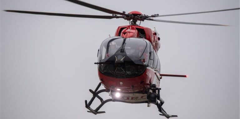 Ein Rettungshubschrauber fliegt über den Flugplatz eines Krankenhauses.