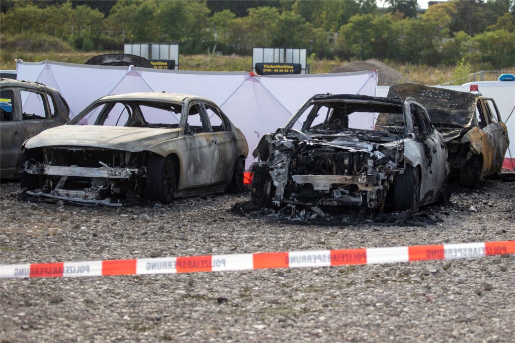 Ausgebrannte Fahrzeuge stehen auf einem Parkplatz vor dem Zelt des Zirkus FlicFlac, nachdem dort ein Kleinflugzeug abgestürzt war.