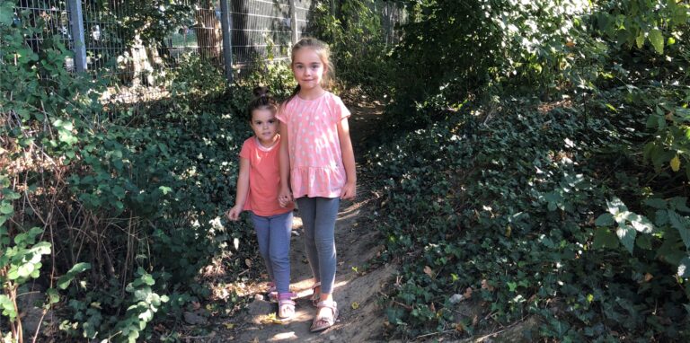 Jolie (7) geht in Unna-Hemmerde mit ihrer kleinen Schwester Demi über einen Pfad ins Wohngebiet Große-Oetringhaus-Straße.