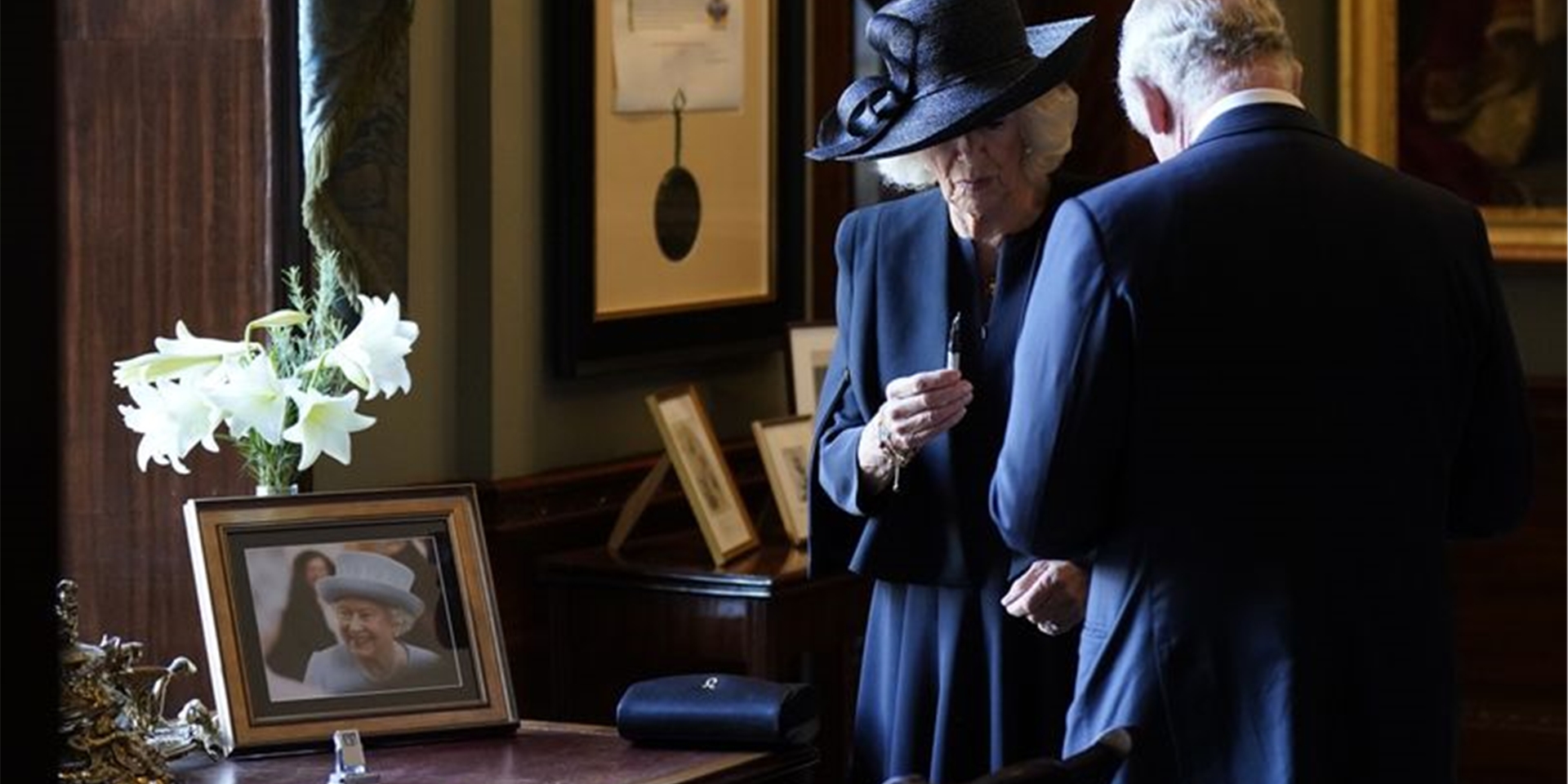 Königin Camilla hält einen Füllfederhalter, während sich König Charles III. Tinte von der Hand wischt. Der Monarch wollte sich in Hillsborough Castle in ein Gästebuch eintragen, als der Stift zu schmieren begann.