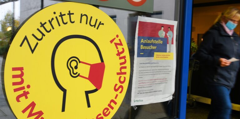 Ein großes Schild mit der Aufschrift «Zutritt nur mit Mund-Nasen-Schutz!» weist neben einem Eingang zu einer Klinik in Leipzig auf die Maskenpflicht hin.