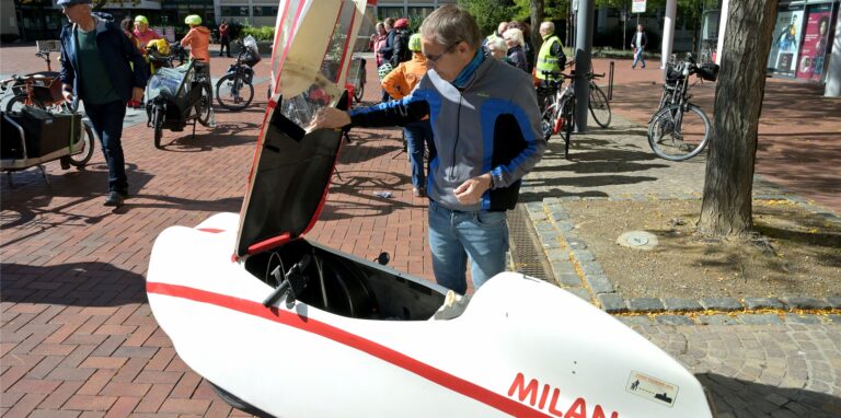 Ein Mann schaut sich während der Lastenrad-Parade des ADFC ein Lastenfahrrad an.