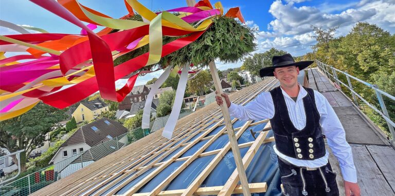 Zimmermeister Peter Heussen steht am Montag (19. September) bei strahlendem Sonnenschein am Richtkranz auf einem Neubau in Königsborn.