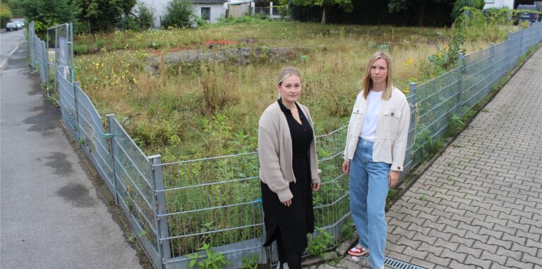 Die Firma HSI würde gerne ein Sechs-Parteien-Haus bauen, wartet aber lange auf eine Genehmigung. Mitarbeiterin Maike Hölting (l.) und Geschäftsführerin Marina Schabsky zeigen das Grundstück, auf dem bisher nur Wildpflanzen anstelle von Mauern in die Höhe schießen.