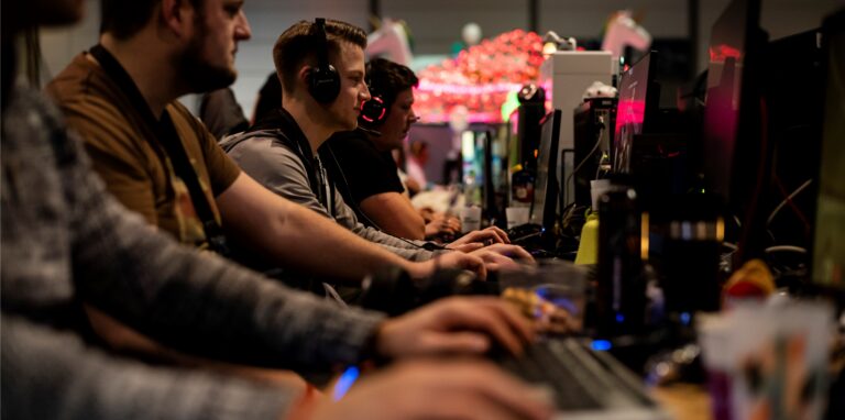 Computerspieler blicken konzentriert auf ihre Bildschirme.