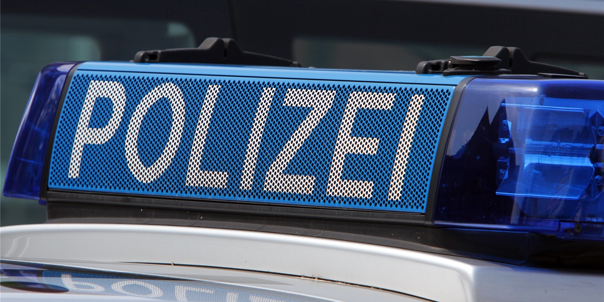 Ein Schild mit der Aufschrift Polizei auf einem Streifenwagen