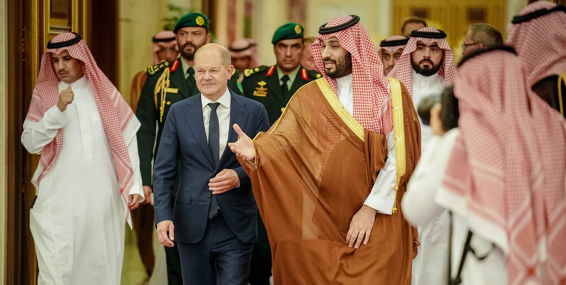 Bundeskanzler Olaf Scholz (SPD) wird vom Kronprinzen des Königreichs Saudi-Arabien Mohammed bin Salman al-Saud (Mitte r) und einer Delegation im Al-Salam-Palast empfangen.