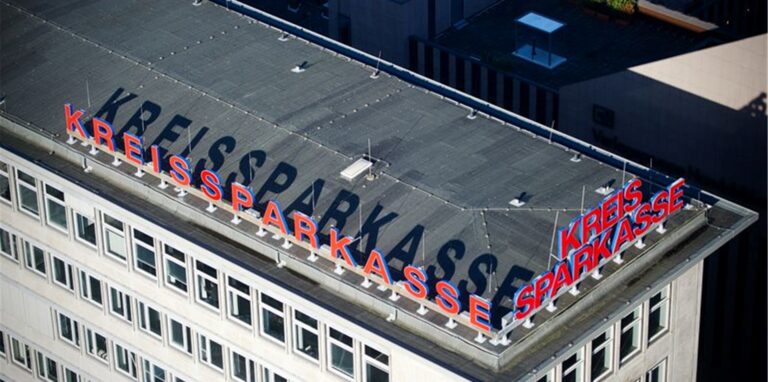 Das Logo der Kreissparkasse Düsseldorf wirft in Düsseldorf einen langen Schatten.