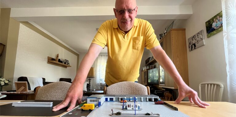 Reimund Fischer beugt sich über sein Tankstellen-Modell.