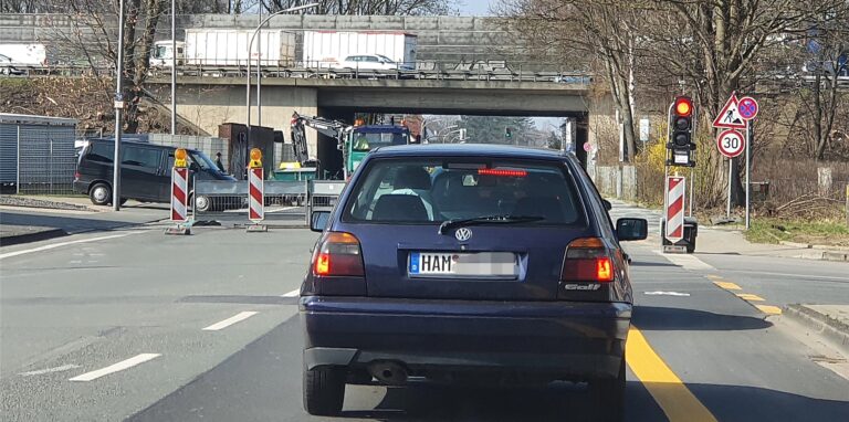 Ein Auto steht vor der roten Baustellenampel.