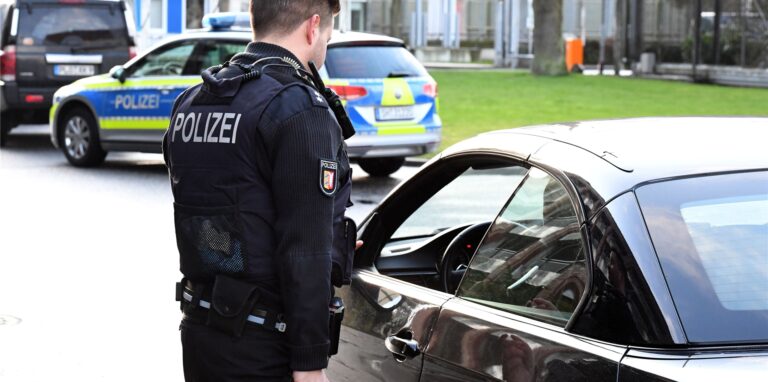 Ein Polizist führt eine Fahrzeugkontrolle durch.