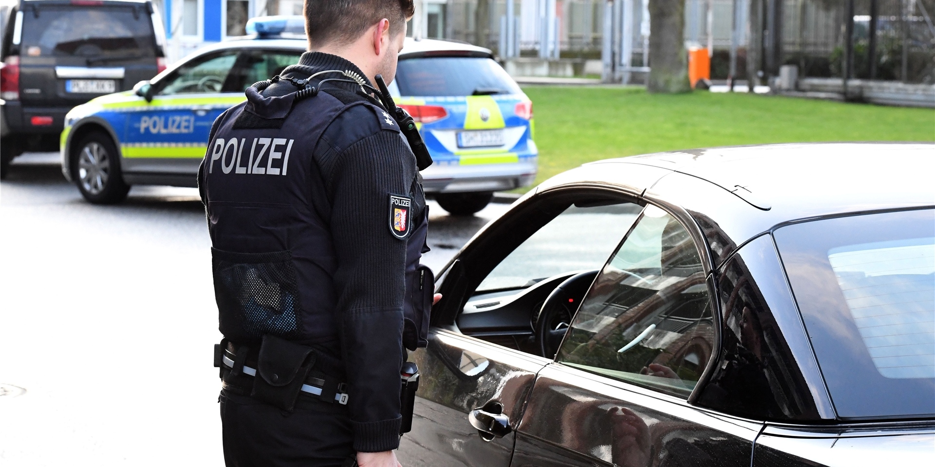 Ein Polizist führt eine Fahrzeugkontrolle durch.
