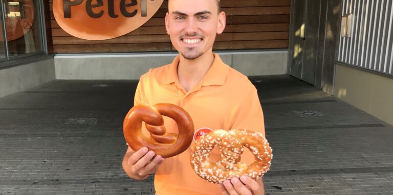 Alexander Peter steht vor einer Filiale der Bäckereikette „Peter“.