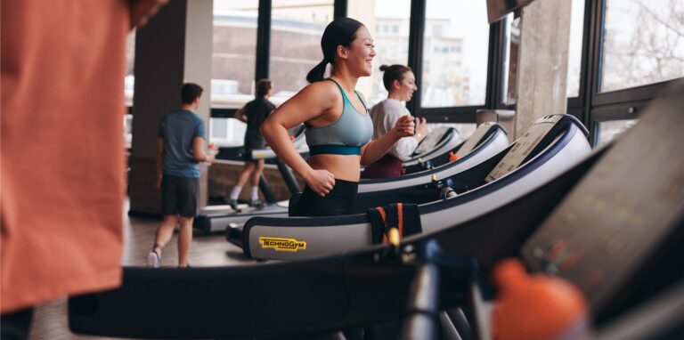 Laufende Menschen auf Fitness-Geräten.