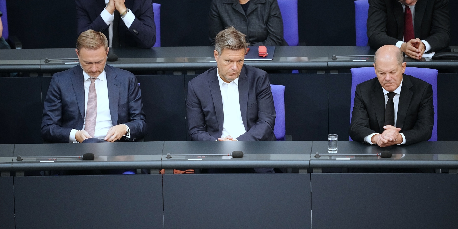 Finanzminister Christian Lindner (FDP, v.l.), Wirtschaftsminister Robert Habeck (Bündnis 90/Die Grünen) und Bundeskanzler Olaf Scholz (SPD) sitzen gemeinsam im Bundestag.