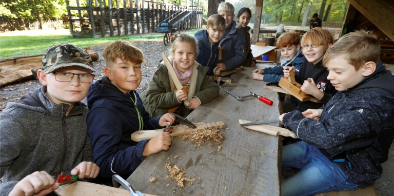 Die Kinder lernen im Holzworkshop im Römerpark Bergkamen, welche Holzart sich für welches Projekt eignet, warum Holz so wichtig ist – und natürlich auch, wie man damit etwas herstellt. Schwerter und Messer zum Beispiel.