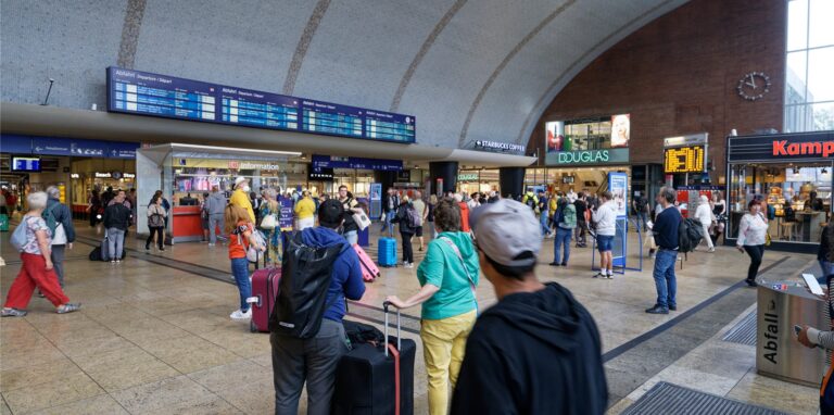 Reisende gehen durch die Bahnhofshalle im Kölner Hauptbahnhof.