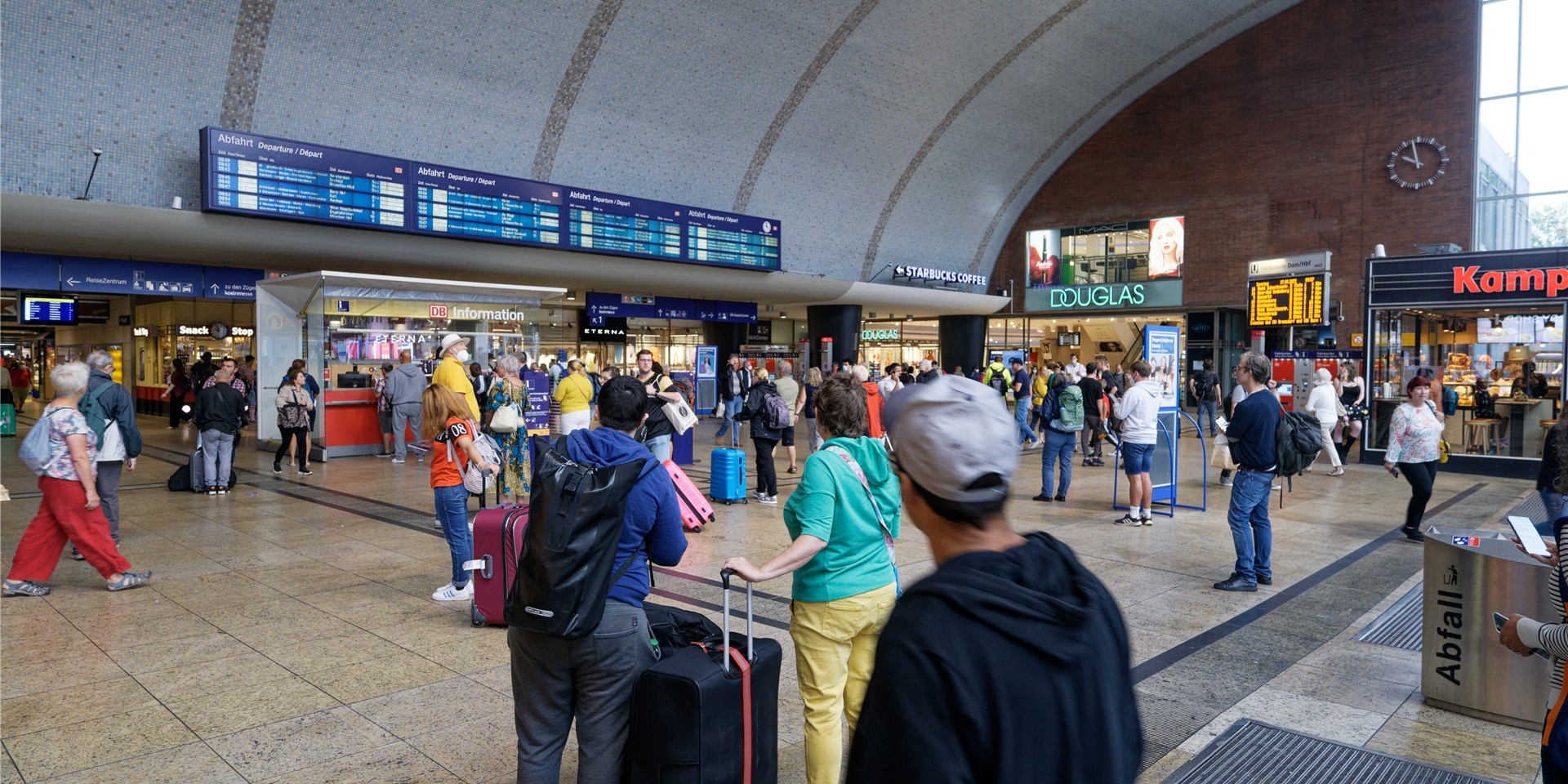 Reisende gehen durch die Bahnhofshalle im Kölner Hauptbahnhof.