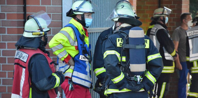Feuerwehrleute unterhalten sich am Rande eines Einsatzes.