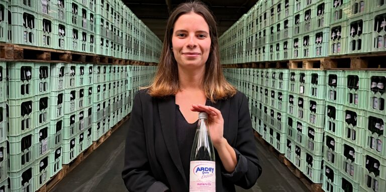 Sommelière Annika Kosubek präsentiert eine Flasche Ardey-Mineralwasser in der großen Lagerhalle der Dortmunder Ardey-Quelle