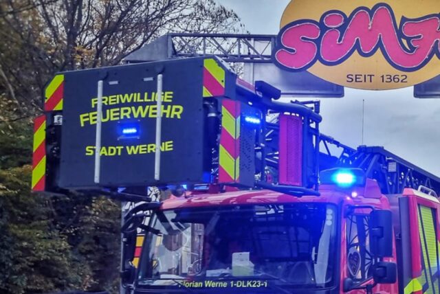 Ein Fahrzeug der Freiwilligen Feuerwehr fährt unter einem Sim-Jü-Schild her.