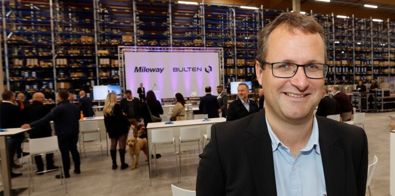 Johannes Hammer lächelt, im Hintergrund sind Menschen zu sehen.