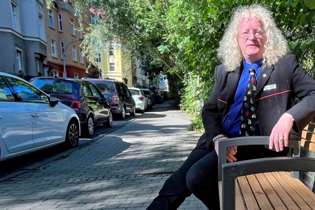 Bezirksbürgermeister Friedrich Fuß auf der Bank, die mittlerweile keine Armlehnen mehr hat.