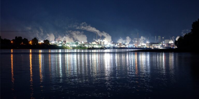 Die Lichter des Chemparks in Leverkusen spiegeln sich im Wasser des Rheins.