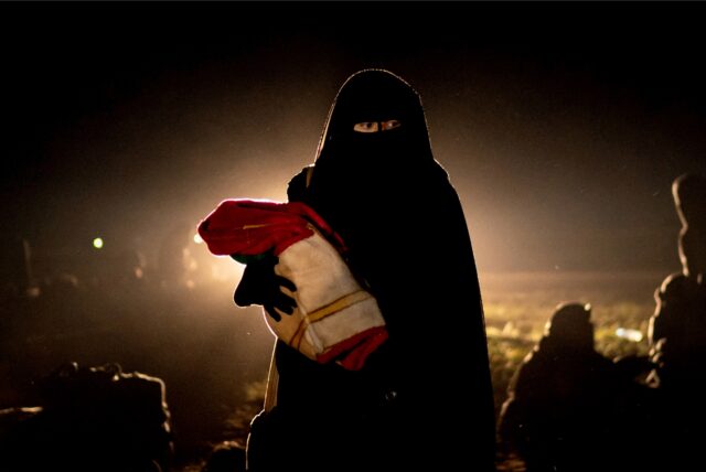 Eine Frau hält in Syrien ihr Kind auf dem Arm.