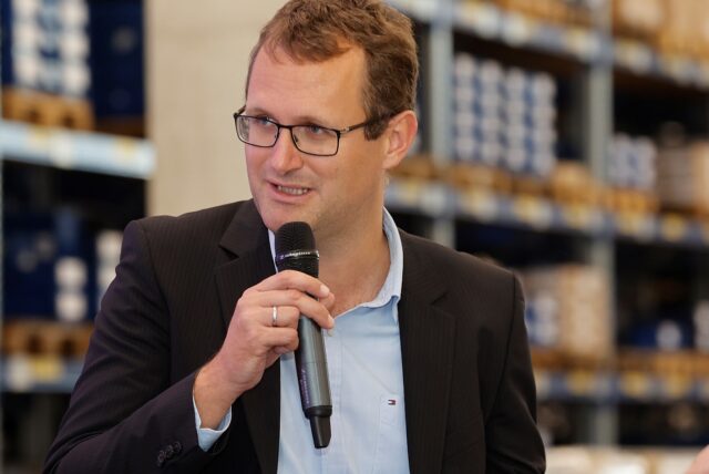 Johannes Hammer mit einem Mikrofon in der Hand.