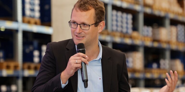 Johannes Hammer mit einem Mikrofon in der Hand.
