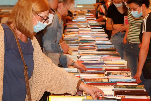 Menschen schauen eine Reihe von Büchern an.