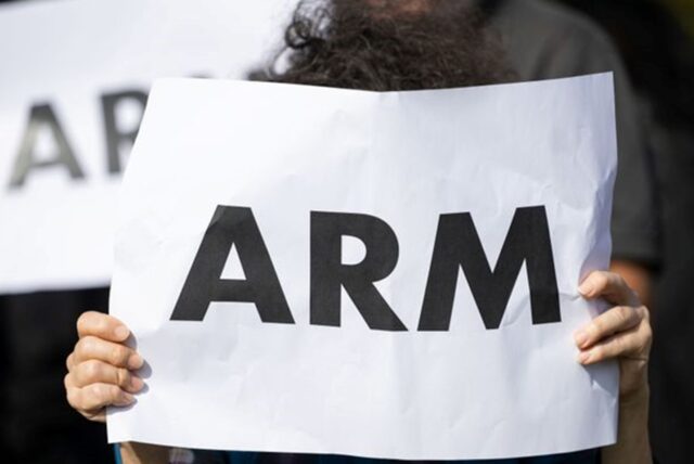 Eine Frau hält ein Schild hoch, auf dem „arm“ steht.