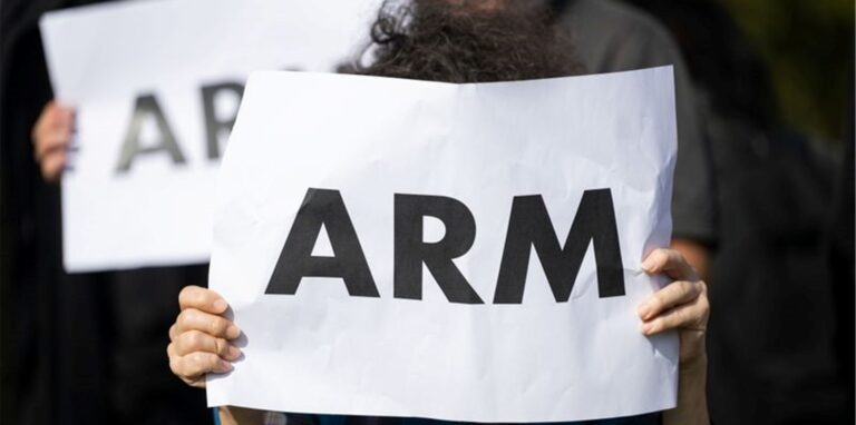 Eine Frau hält ein Schild hoch, auf dem „arm“ steht.